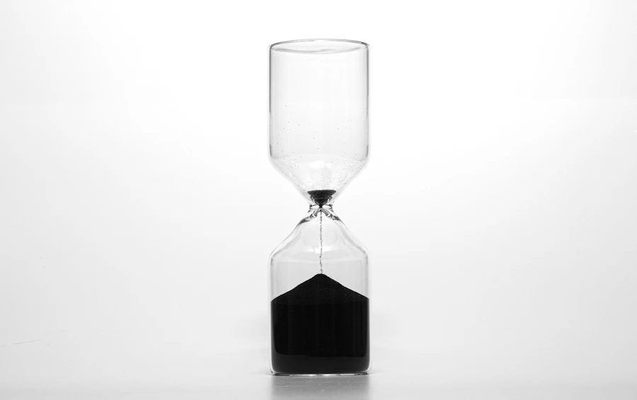 Hourglass with black sand against a white background