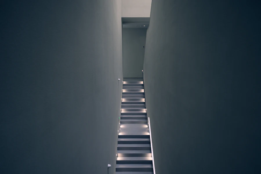 Dark concrete staircase rising between two tall walls