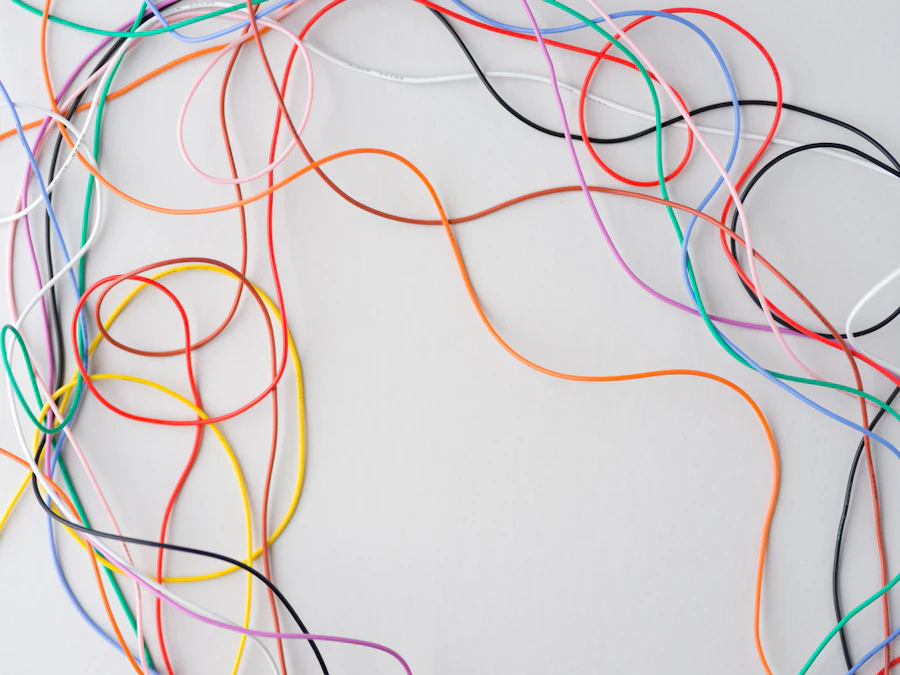 Coloured threads tangled against a white background